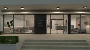 A modern hotel entrance with a reception desk, seating area, and a staircase leading to the interior. -  Angela Downtown Hotel  (Rhodes)