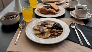 A breakfast setting with plates of pastries, a bowl of granola, a glass of orange juice, and a cup of coffee. -  Angela Downtown Hotel  (Rhodes)