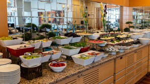 Un bufé con diferentes opciones de comida y un espejo decorativo.