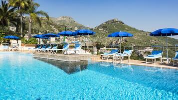 Una piscina al aire libre de temporada, sombrillas