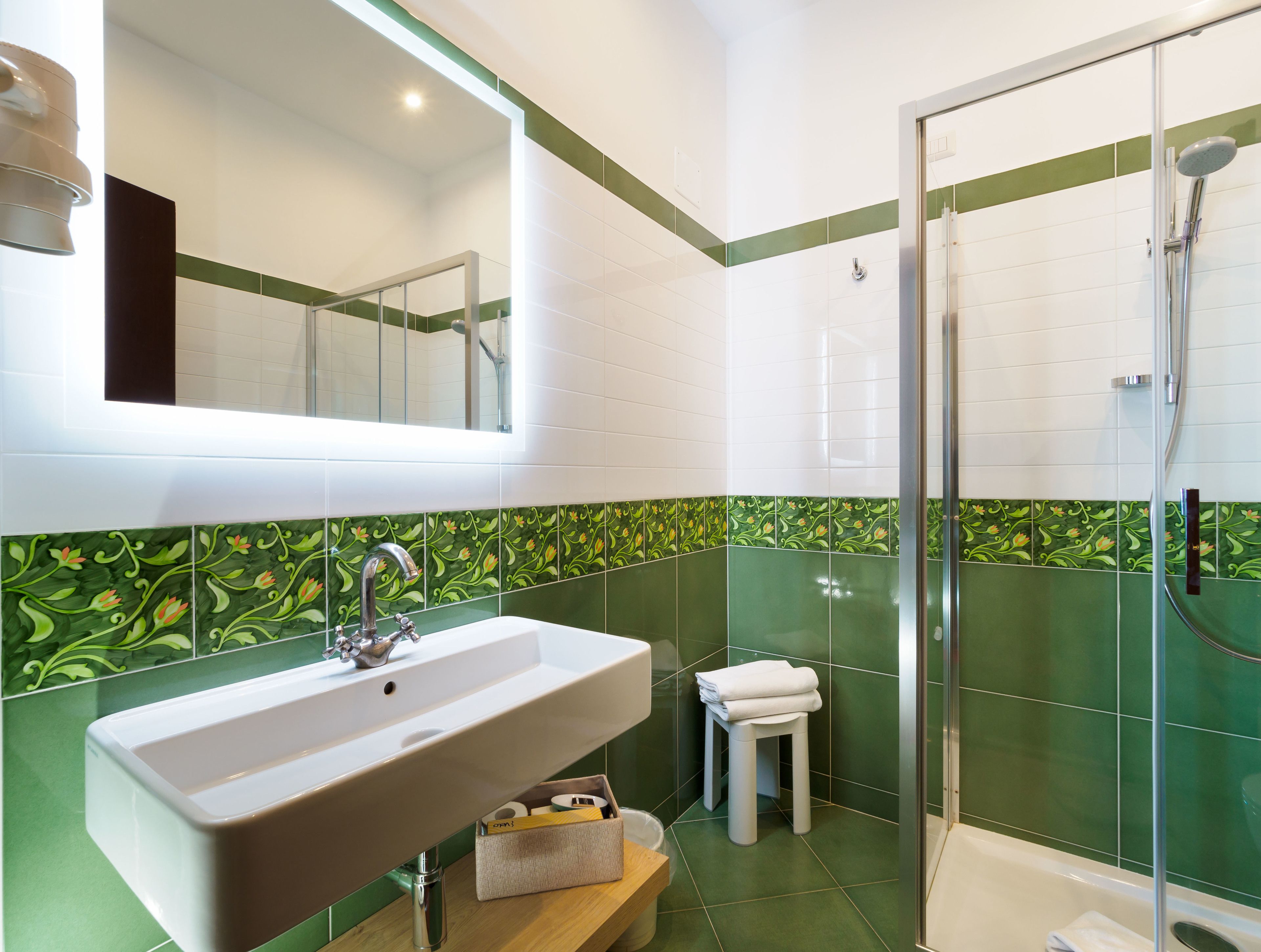 A bathroom with a sink, mirror, toilet, and shower.