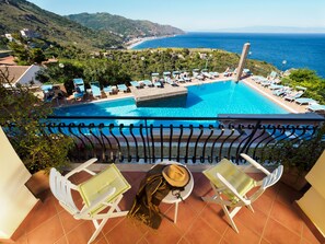 A balcony with a pool, overlooking a coastal area with a view of the sea and hills. - Hotel Sirius (Taormina)