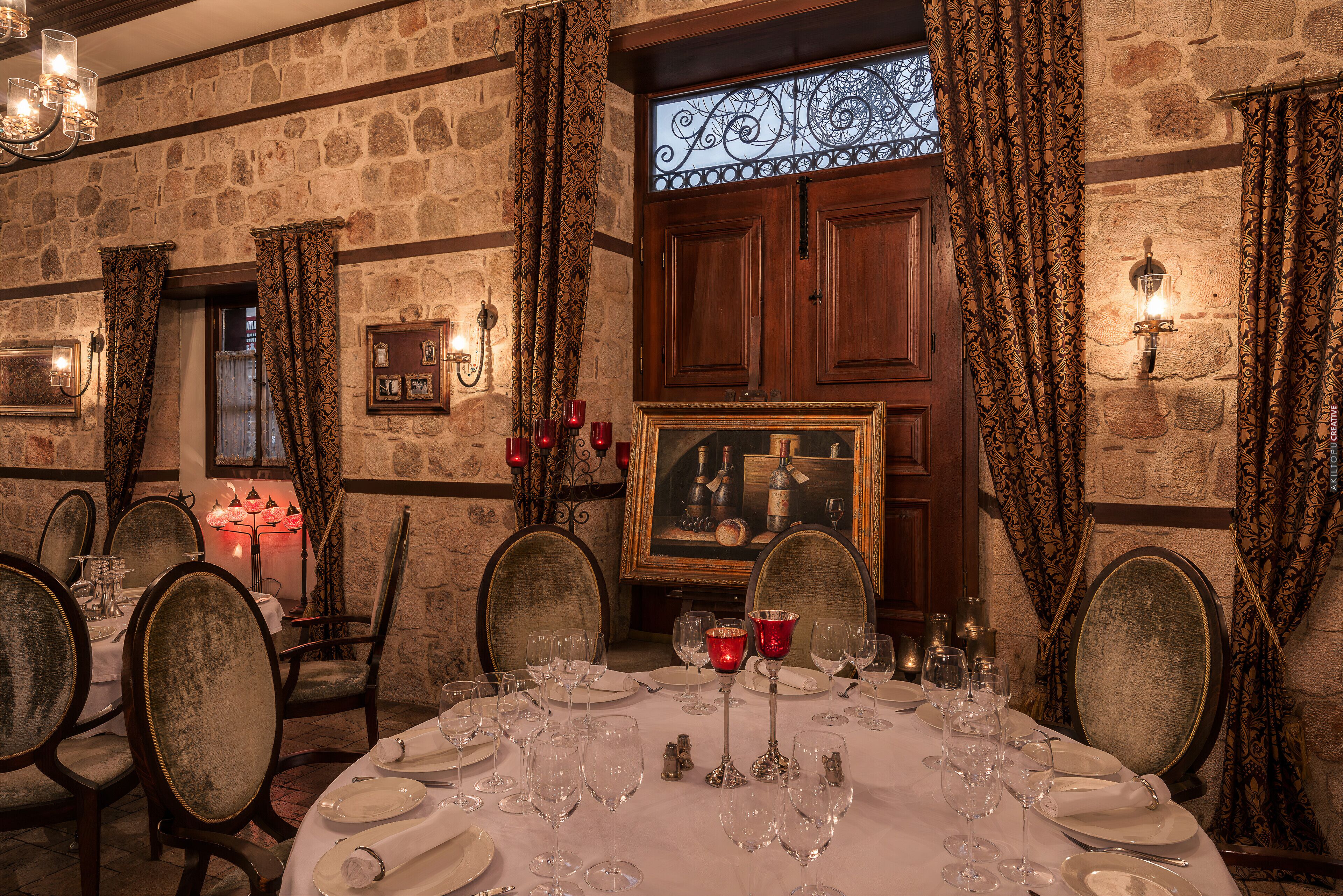 A dining room with a stone wall, wooden cabinets, and a large mirror.