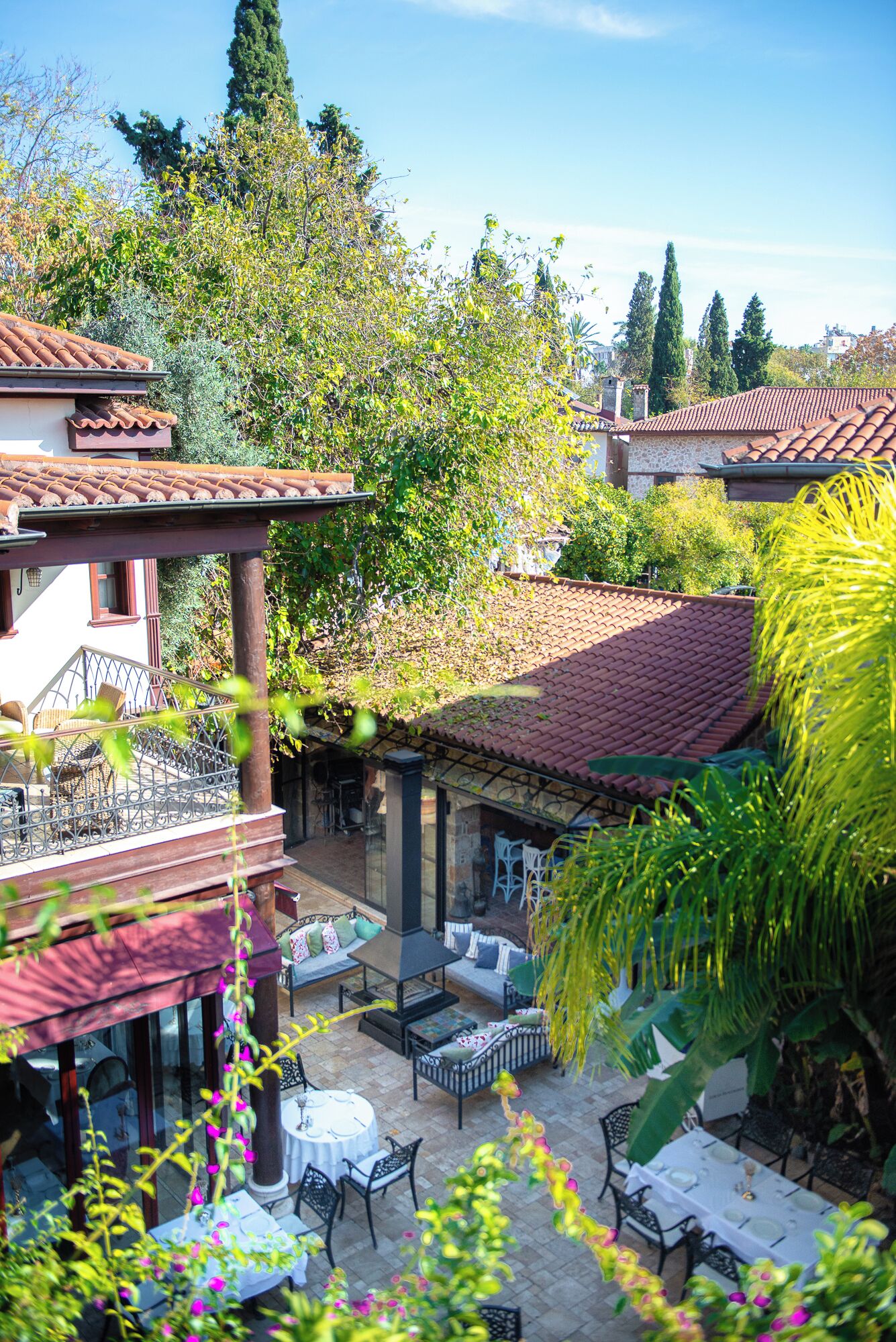 A courtyard with outdoor seating, a pergola, and a view of surrounding buildings.