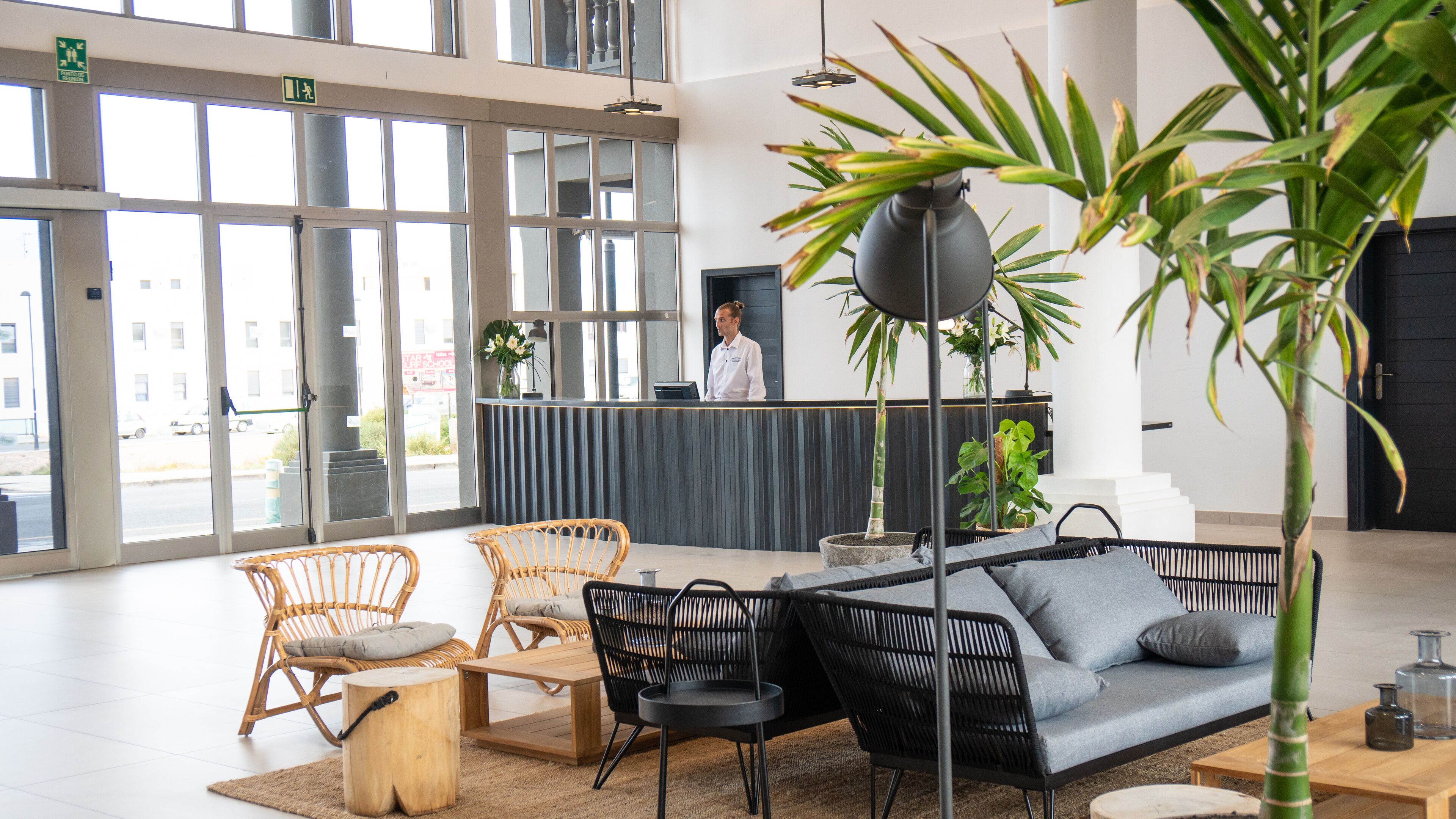 A reception area with wicker chairs, a sofa, and a reception desk.