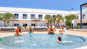 Relax by the pool surrounded by lush greenery and lounge chairs.