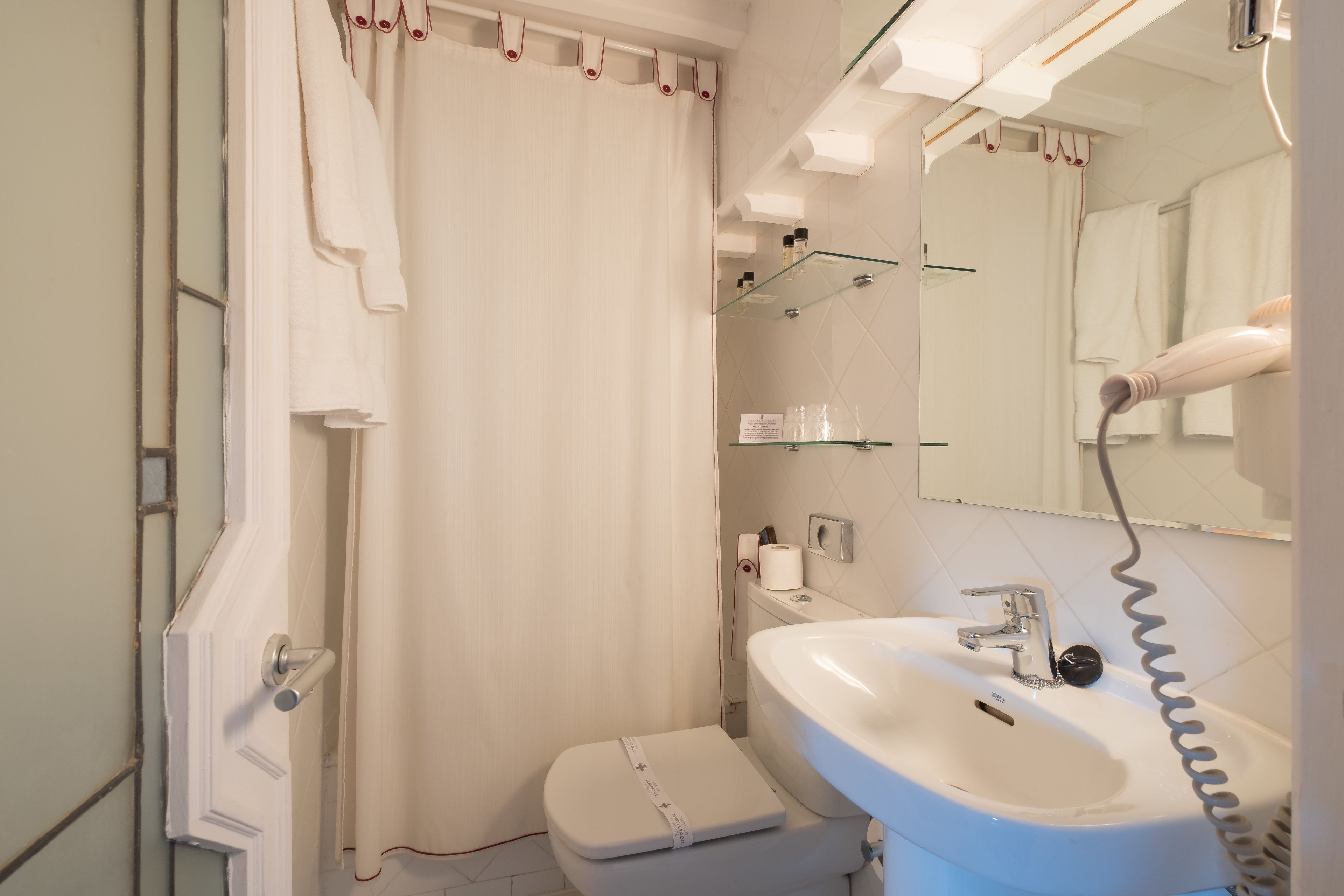 Een badkamer met toilet, wastafel en douchegordijn.