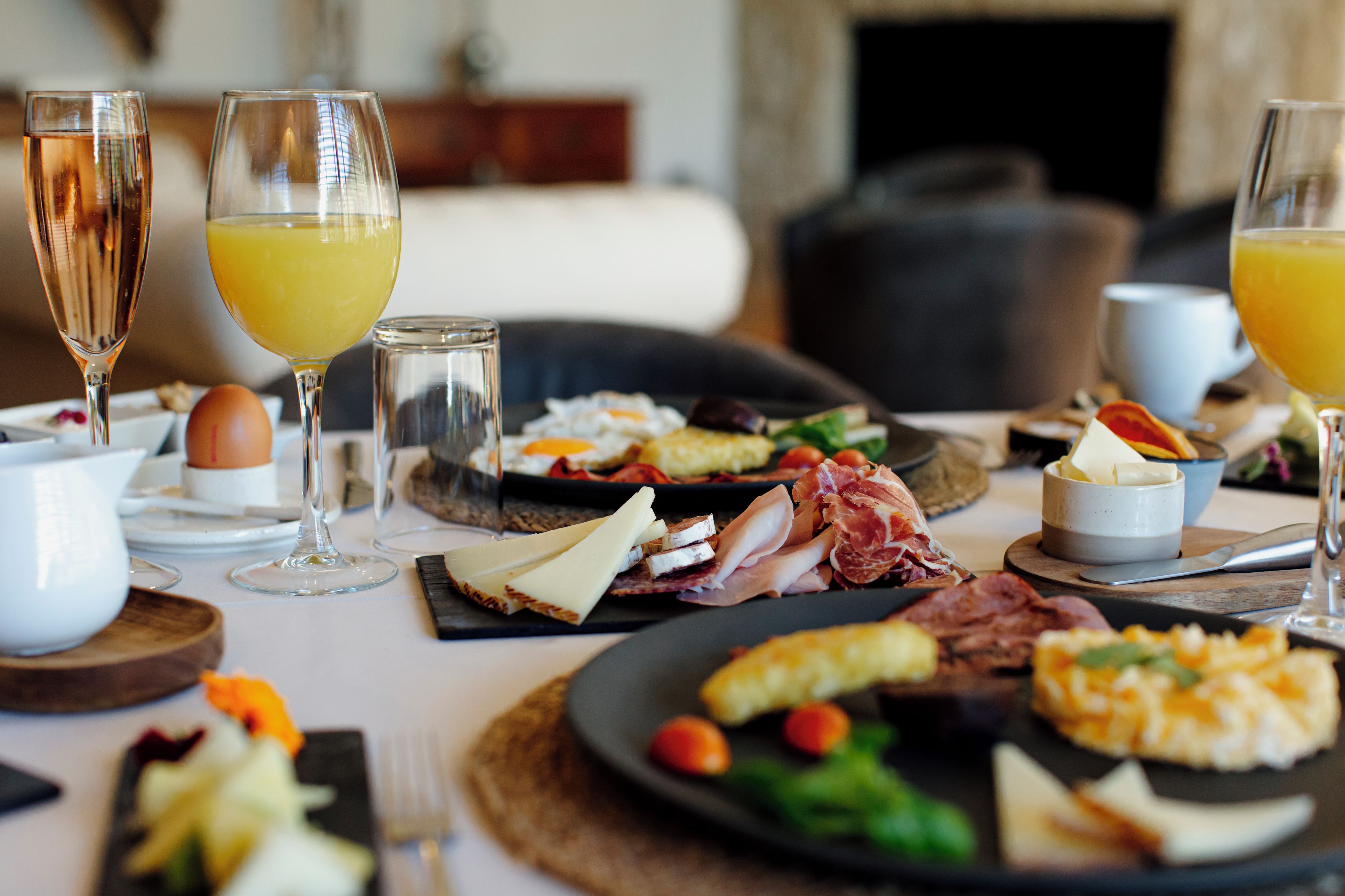 A breakfast setting with various food items and drinks on a table.