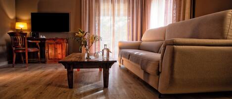 A living room with a sofa, wooden coffee table, and a TV mounted on the wall.