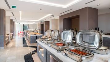 A buffet area with multiple food stations, a marble countertop, and a clean, modern design.