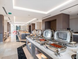 A buffet area with multiple food stations, a marble countertop, and a clean, modern design.