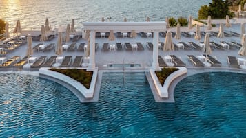 Piscine couverte, piscine extérieure, parasols de plage, chaises longues