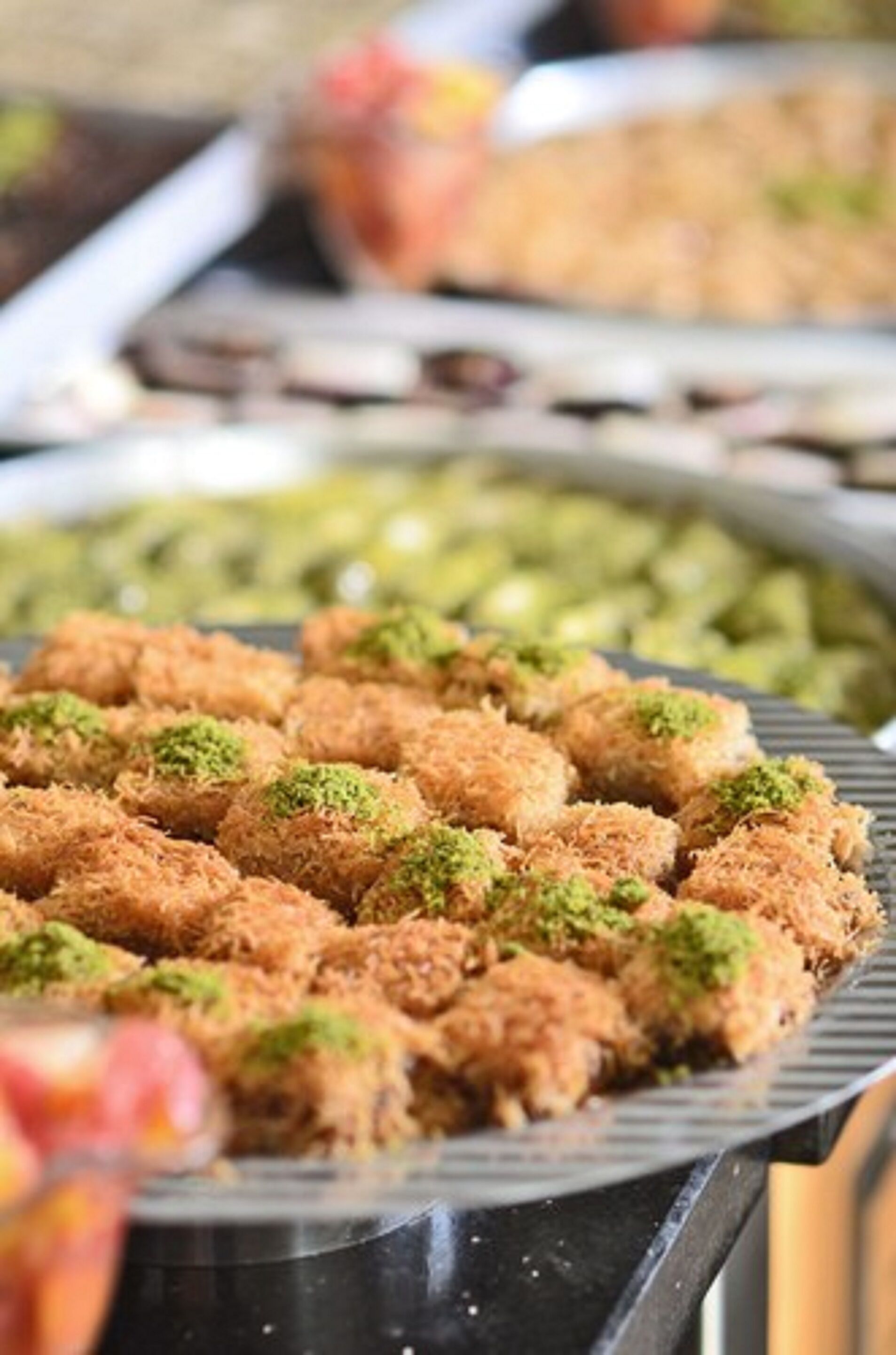 A tray of food items, likely a dessert, with a focus on a dish garnished with green toppings.