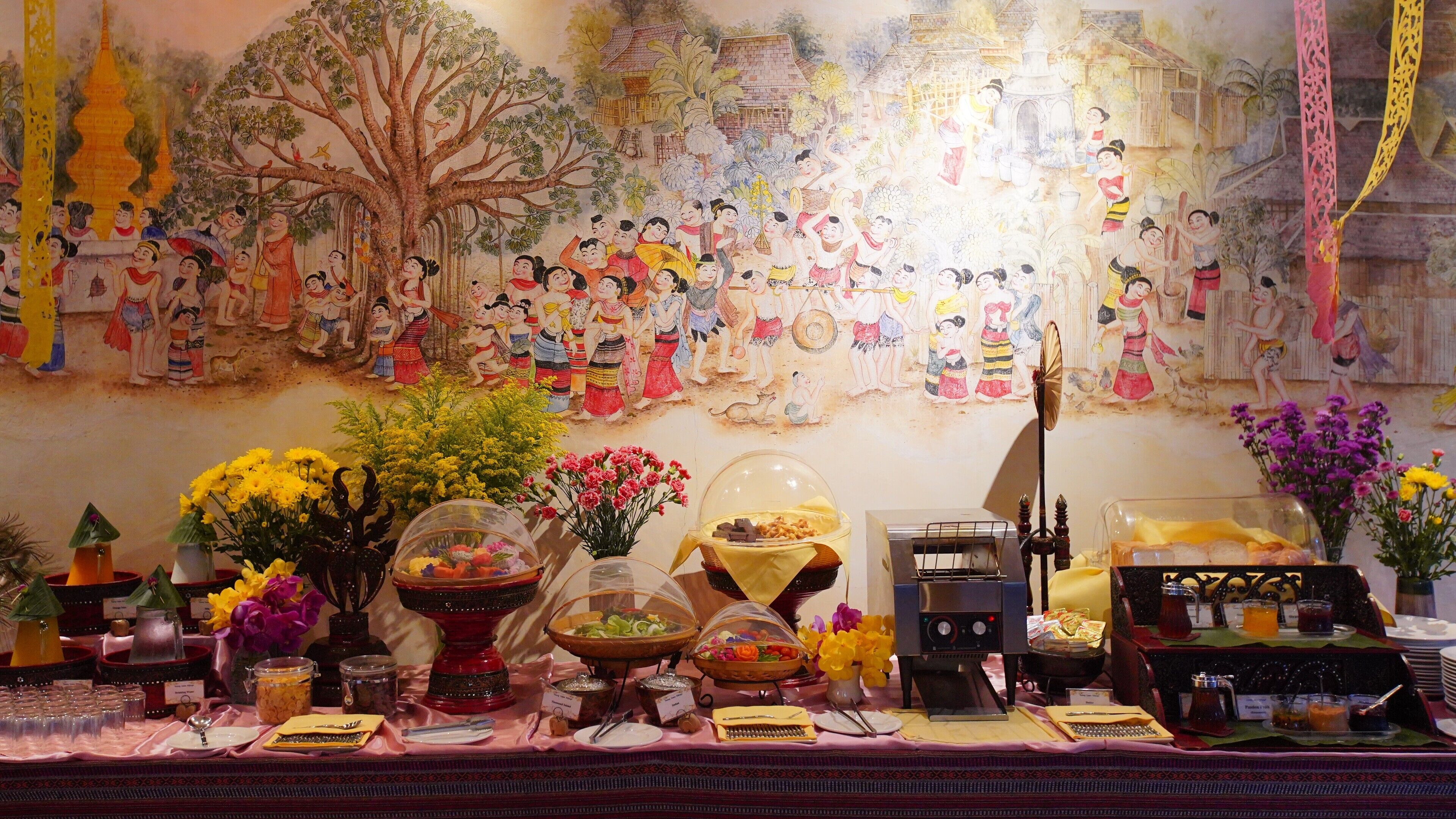 Ein dekorierter Raum mit Wandmalerei, einem Buffet und traditioneller Dekoration.