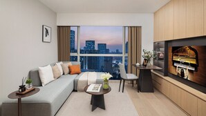A modern living room with a sofa, coffee table, and a piano. - Ascott Guangzhou (Guangzhou)