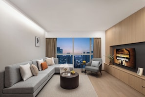 A modern living room with a sectional sofa, a round coffee table, a piano, and a large window with a city view. - Ascott Guangzhou (Guangzhou)