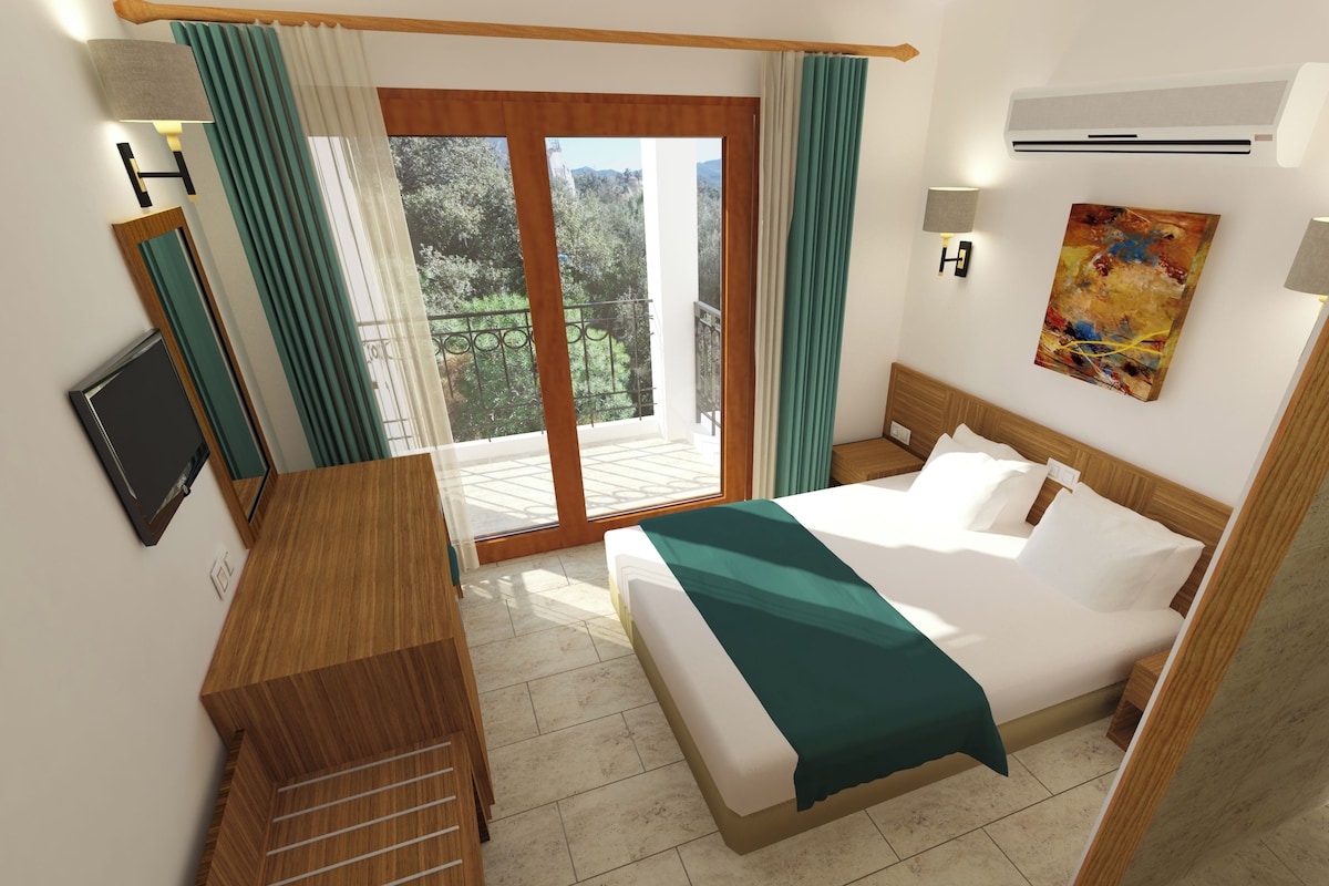 A hotel room with a bed, a desk, a TV, a painting, and a view of greenery through the window.