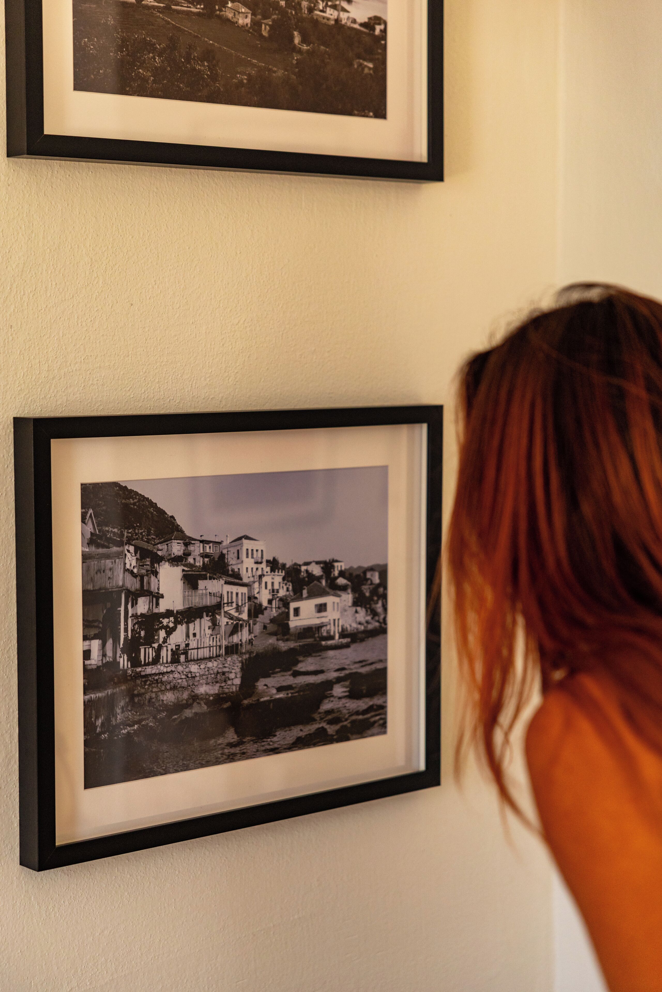 Een muur met twee zwart-witfoto's in lijsten.
