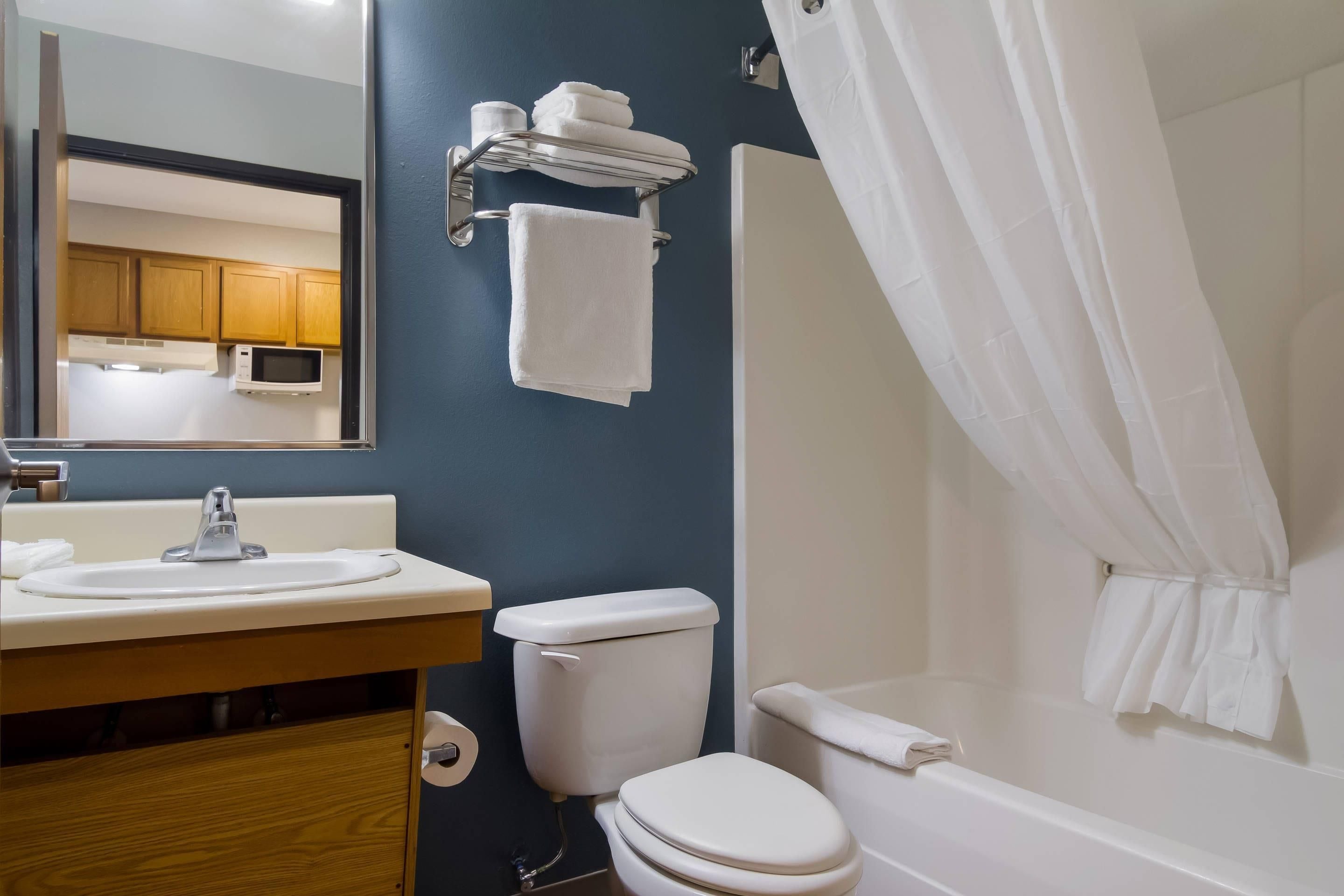 A bathroom with a sink, toilet, and shower area.