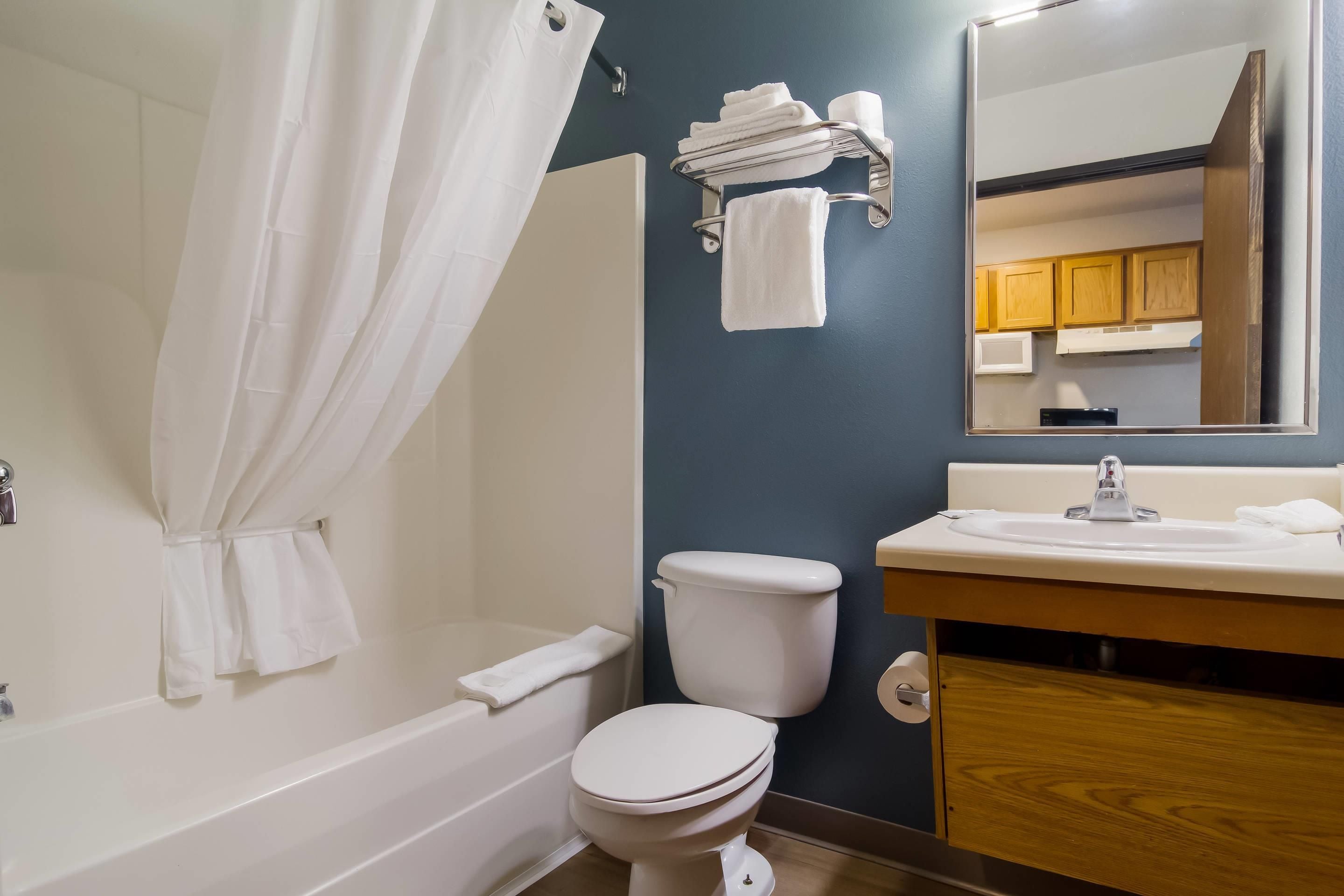 A bathroom with a bathtub, toilet, sink, and a towel rack.