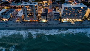 Un hotel frente al mar con varias plantas y una zona de piscina.