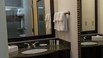 A bathroom with two sinks, a large mirror, and a towel rack.