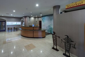 A reception area with a wooden reception desk, a computer, and two chairs.