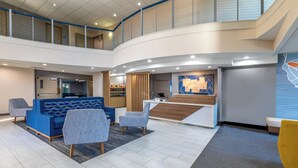 A modern lobby with a reception desk, seating area, and a staircase. - Holiday Inn Express & Suites Lathrop by IHG (Lathrop)