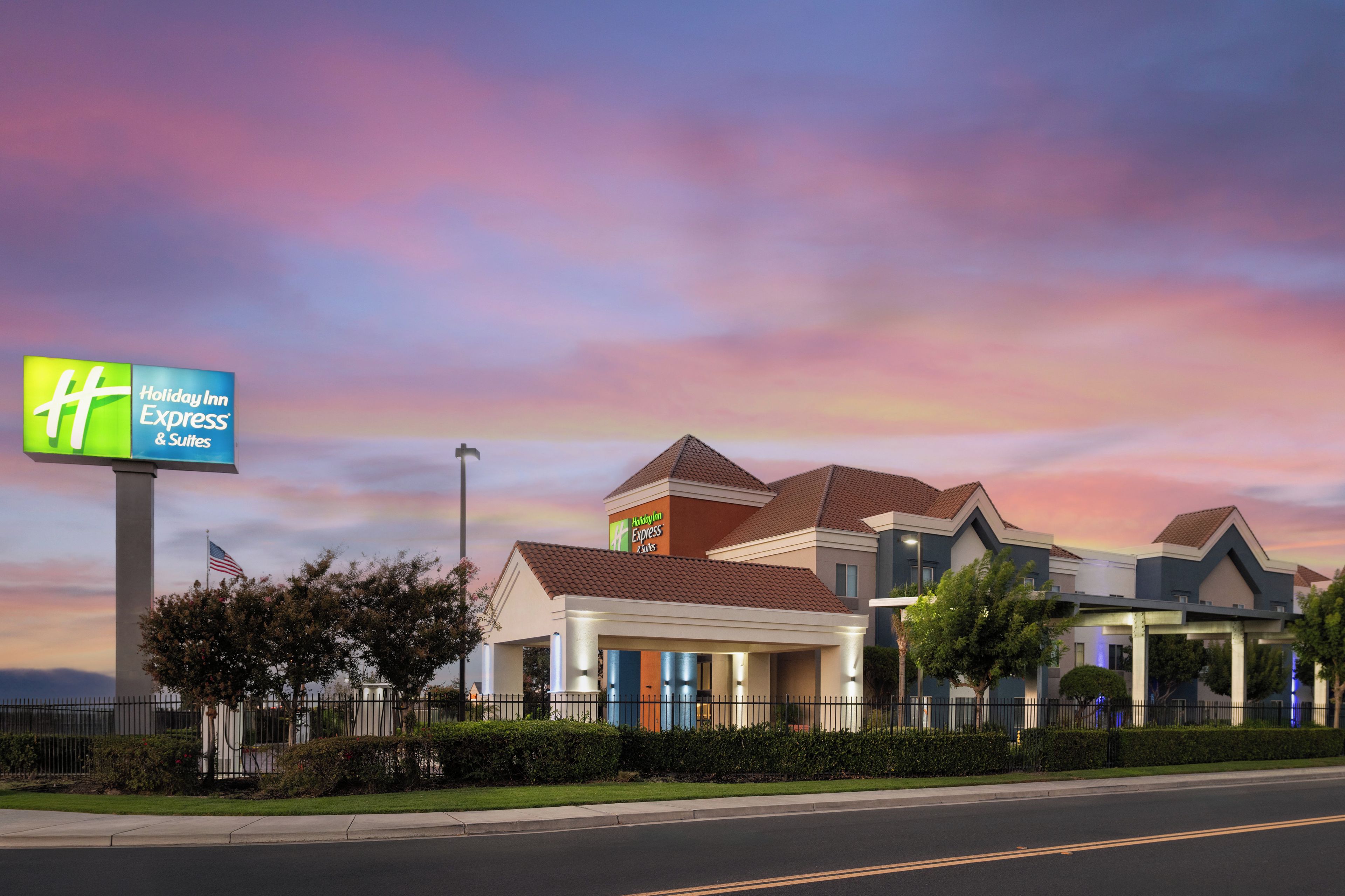 A Holiday Inn Express & Suites hotel with a modern architectural design, featuring multiple buildings and a prominent sign.