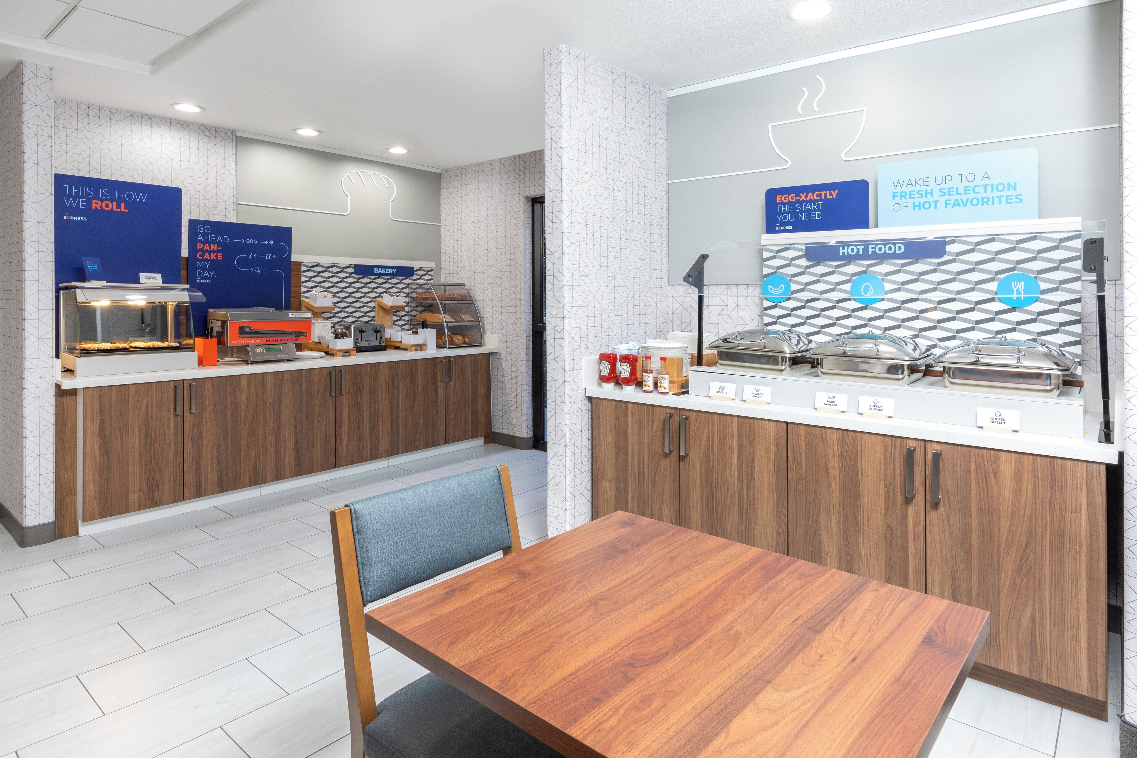 A modern breakfast area with a counter displaying pastries and a coffee station.