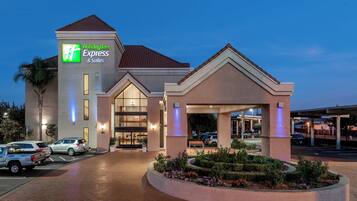 A Holiday Inn Express & Suites hotel with a parking lot, entrance, and landscaped garden.