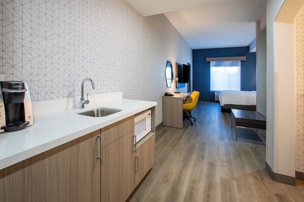 A modern hotel room with a kitchenette, a bed, a desk, and a bathroom. - Holiday Inn Express & Suites Lathrop by IHG (Lathrop)