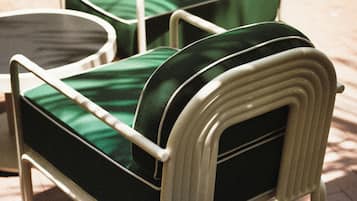 A set of outdoor patio furniture with a metal frame and green cushions.