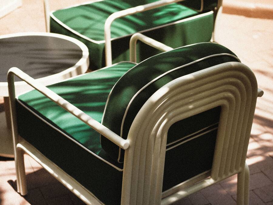 A set of outdoor patio furniture with a metal frame and green cushions.