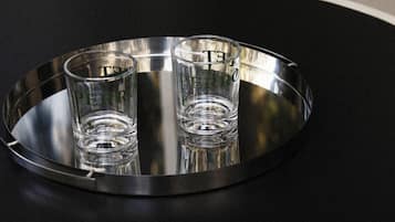 Een metalen dienblad met twee glazen op een ronde tafel.