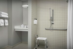 A bathroom with a shower, a sink, and a white towel rack. - TownePlace Suites by Marriott Pensacola (Pensacola)