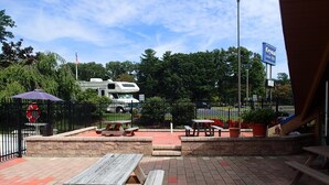 Un patio al aire libre con mesas de picnic y un camino de ladrillos.