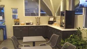 Un restaurante con mostrador, zona de asientos y una pantalla de televisión.