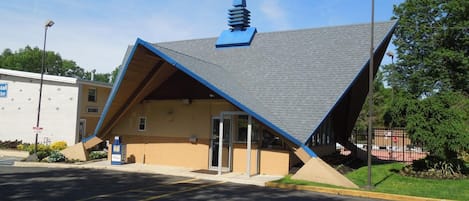 A building with a unique triangular roof and a small spire on top.