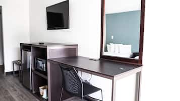 Escritorio, cortinas blackout y tabla de planchar con plancha