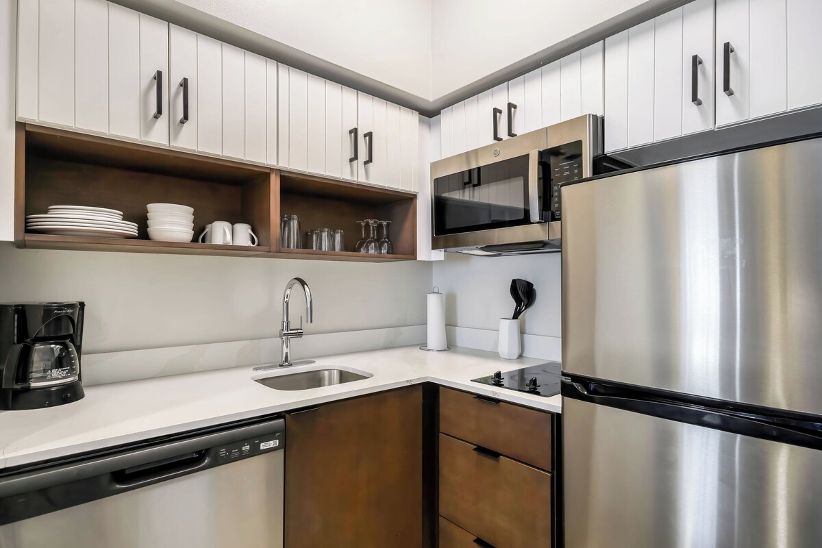 A modern kitchen with white cabinets, stainless steel appliances, and a dishwasher.