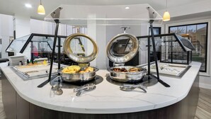 A breakfast buffet with two large round serving stations, each with a glass cover and metal trays. - Staybridge Suites Toledo - Maumee by IHG (Maumee)