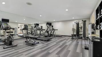 A modern gym with various exercise equipment, including treadmills, stationary bikes, and weight machines.