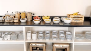 A buffet setup with various food items and utensils.