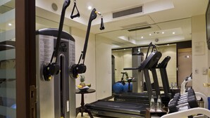 A gym with exercise equipment, including a treadmill, stationary bike, and dumbbells. - Park Silver Obelisco Hotel (Buenos Aires)