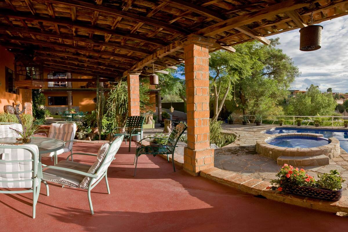 Une terrasse extérieure avec une piscine, un espace salon et une vue sur le paysage environnant.