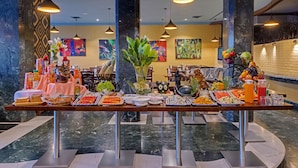 A buffet with various food items and drinks, set in a room with marble flooring and modern lighting. - Amarpreet, Chhatrapati Sambhajinagar - AM Hotel Kollection (Chhatrapati Sambhajinagar)