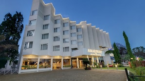 A modern hotel with a unique stepped facade, multiple balconies, and a well-lit entrance. - Amarpreet, Chhatrapati Sambhajinagar - AM Hotel Kollection (Chhatrapati Sambhajinagar)