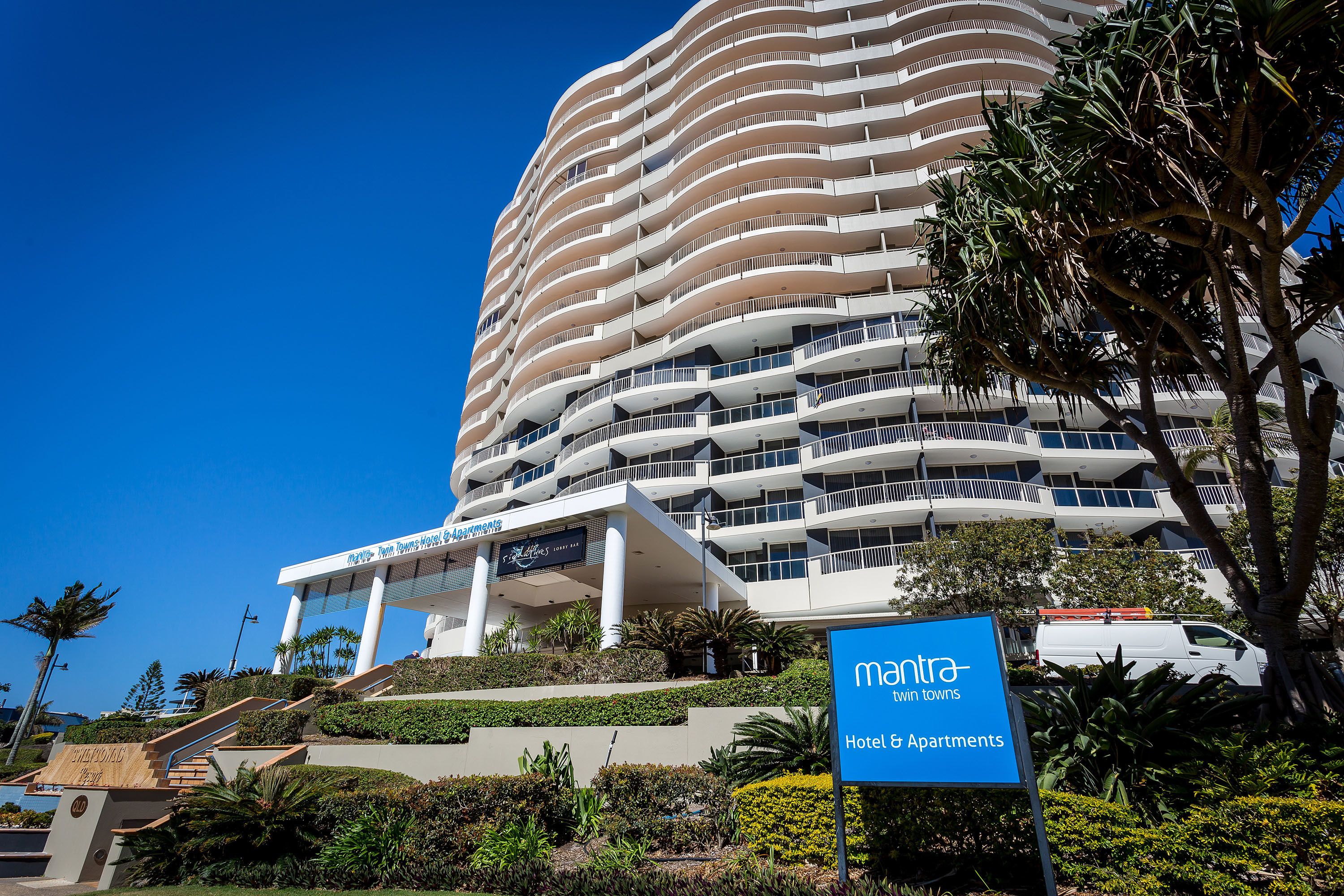 A multi-story hotel with a modern design, featuring balconies and a prominent entrance.