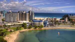 A coastal cityscape with high-rise buildings, a beach, and a clear sky. - Mantra Twin Towns (Tweed Heads)
